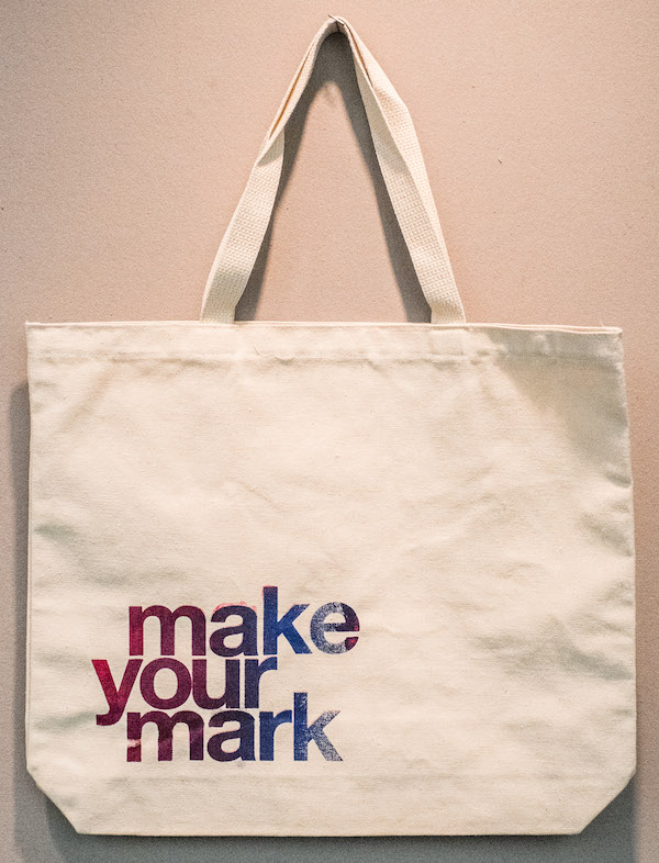 MAKE YOUR MARK Tote Bag: Cyan/Magenta gradient letters on khaki; designs vary